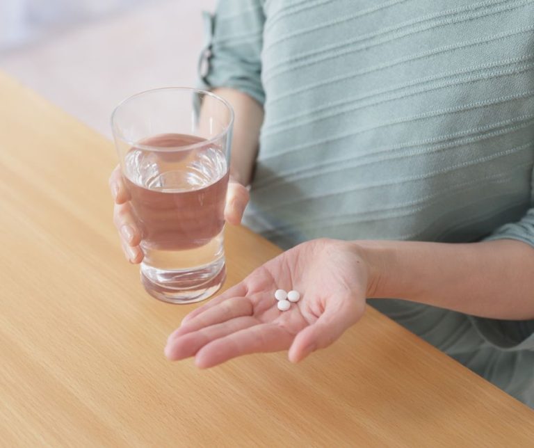 A woman is holding pills symbolizing abortion pill reversal.